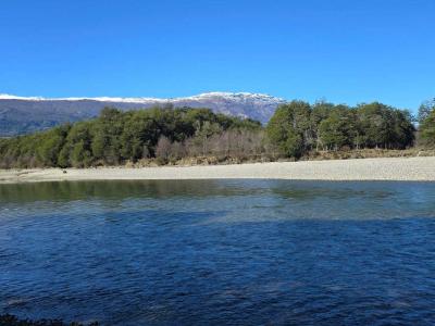 Aerial view of the 46-hectare ranch showing dense forest, open fields, and a river running through the property.